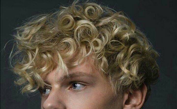 a young man with curly hair and blue eyes