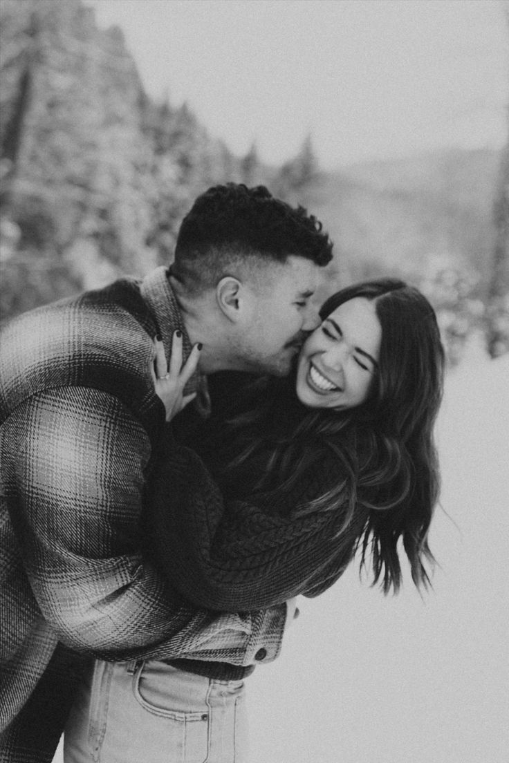 a man and woman are hugging in the snow