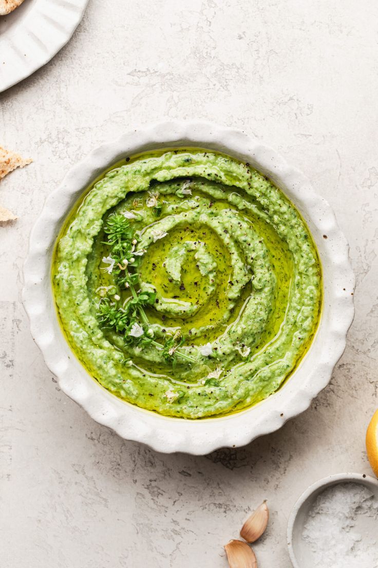 a white bowl filled with green pesto