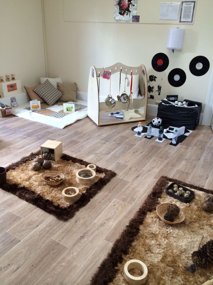 a living room filled with lots of furniture and toys on top of hard wood flooring