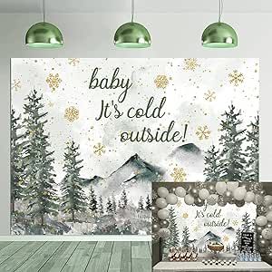 a baby it's cold outside sign in front of a backdrop with snowflakes