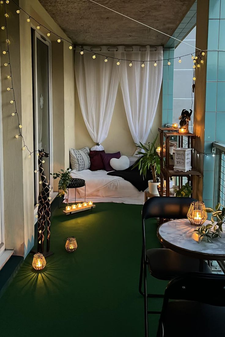 an apartment balcony decorated with string lights and potted plants on the table, next to a bed