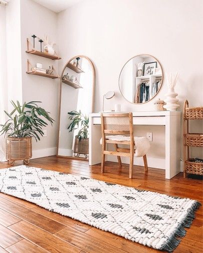 a living room with wooden floors and white walls, including a rug on the floor