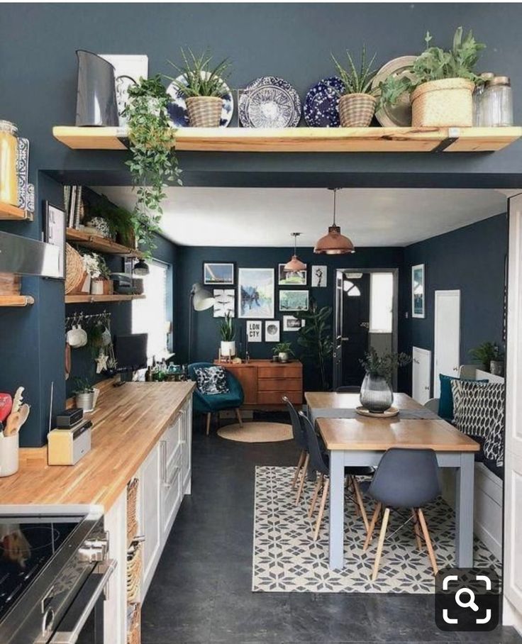 the kitchen is decorated in blue and white with plants on the shelves above the table