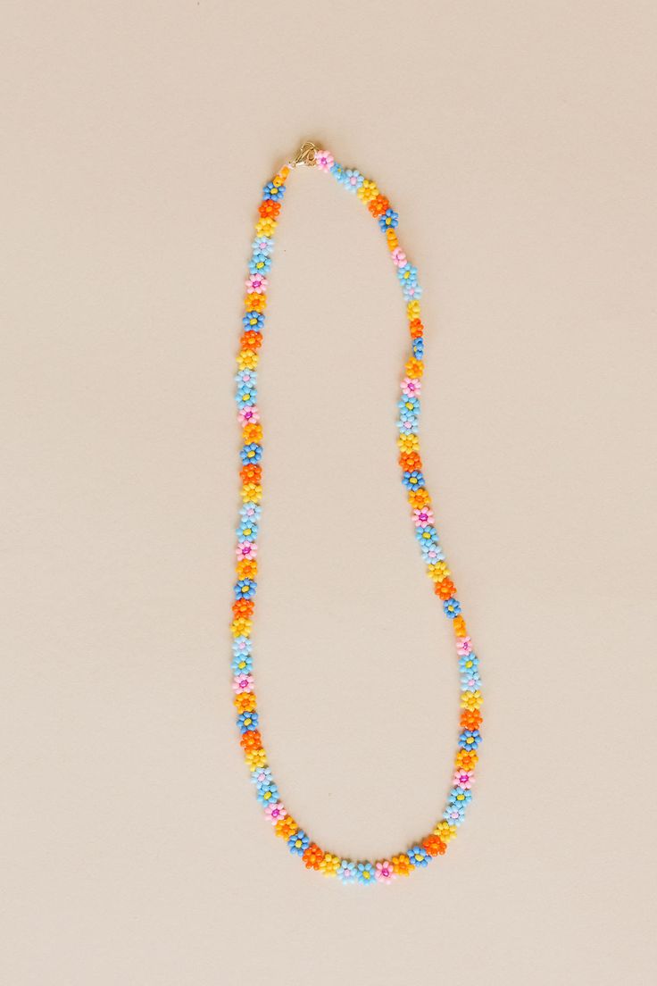 Nothing like a little daisy chain that lasts a lifetime. The Zara is hand beaded with so much love. One of our original necklaces, we always recommend Zara for a layered look, casual or dressed up, she's a perfect faux choker for everyday wear. Available in summer daisy: our combination of blue, pink, and yellow flowers with varying centers to create a bright poppy combination of flowers. - 3D Daisy chain necklace - 14k Gold fill lobster clasp - Handmade in Mexico - 17" Length 5mm width Trendy Multicolor Flower Necklace For Summer, Trendy Multicolor Summer Flower Necklace, Beaded Flower Necklace For Summer Gifts, Trendy Summer Beaded Necklaces With Flower Shape, Trendy Beaded Flower Necklace For Summer, Trendy Adjustable Flower Necklace, Bohemian Jewelry With Letter Beads For Spring, Trendy Flower-shaped Beaded Necklaces For Summer, Bohemian Spring Jewelry With Colorful Beads