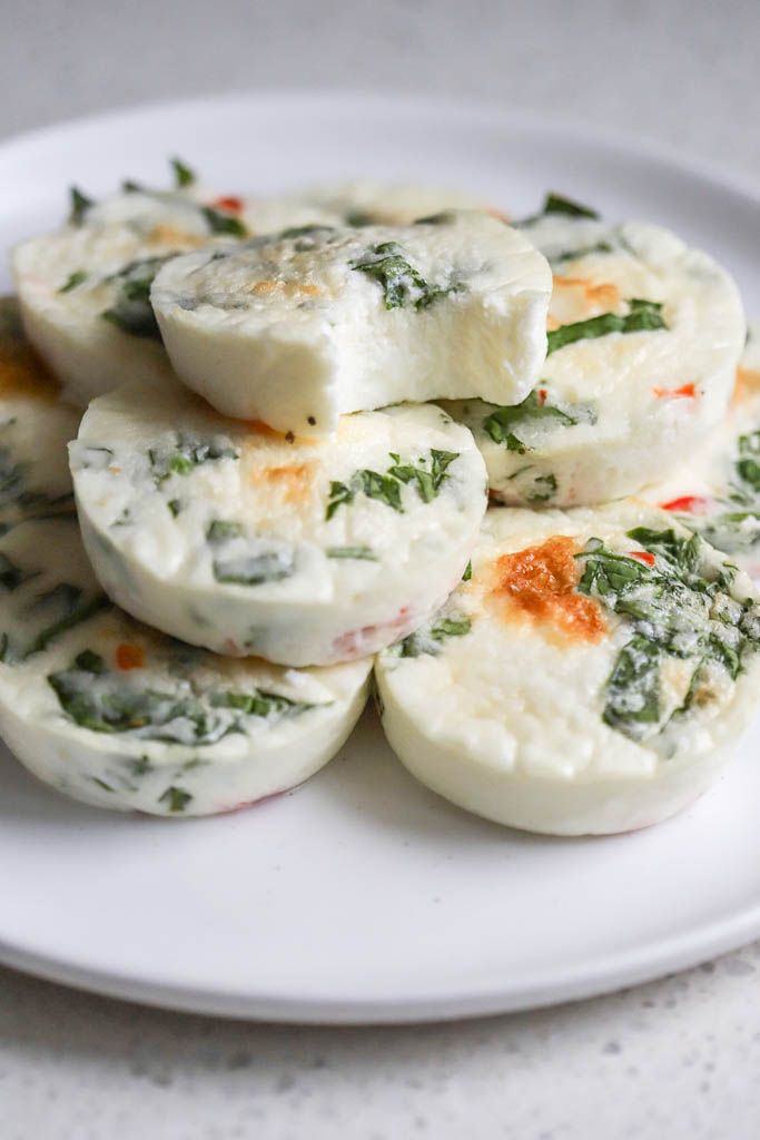 several pieces of food on a plate with sauce and herbs around it, sitting on a table