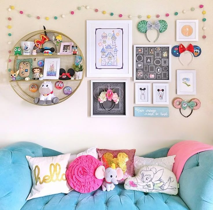 a blue couch sitting in front of a wall with pictures and other items on it