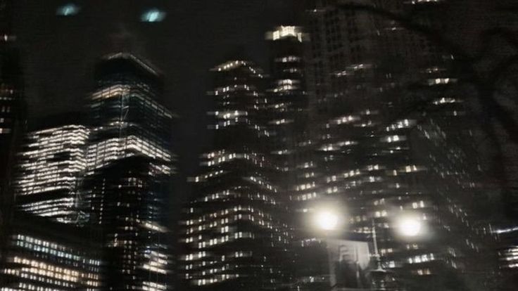 the city is lit up at night with street lights and skyscrapers in the background