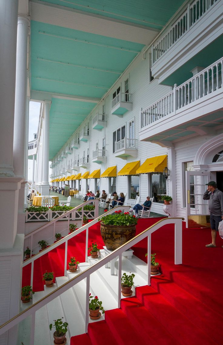 people are walking up and down the red carpeted stairs in a large white building