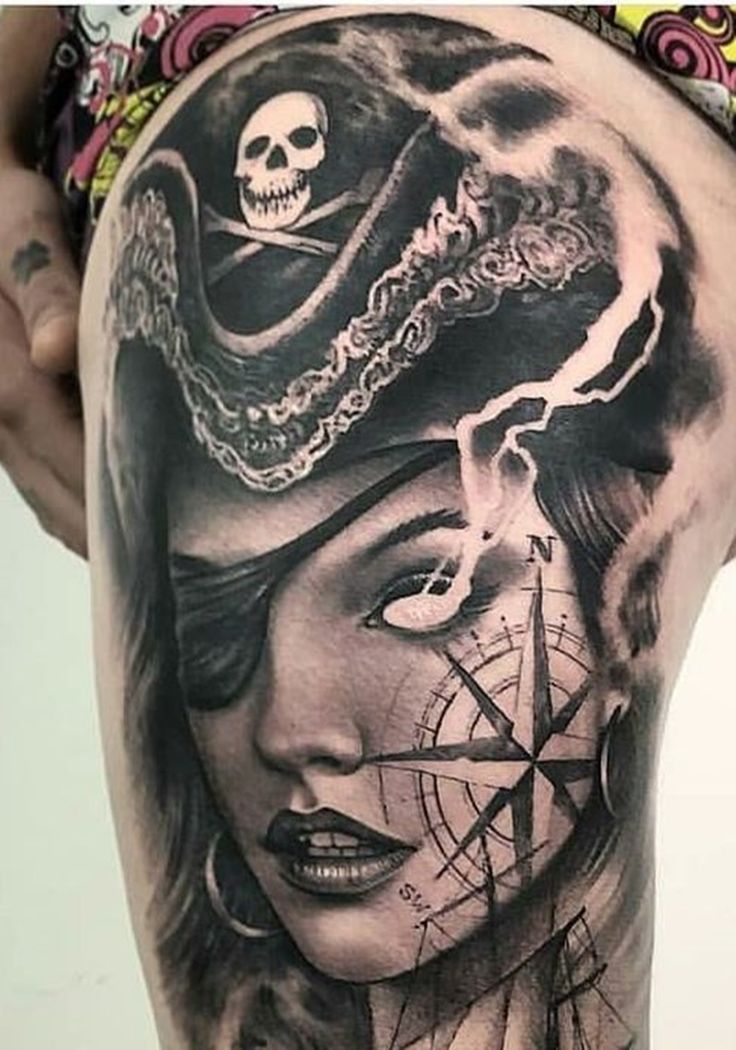 a woman with a pirate hat and compass tattoo on her thigh