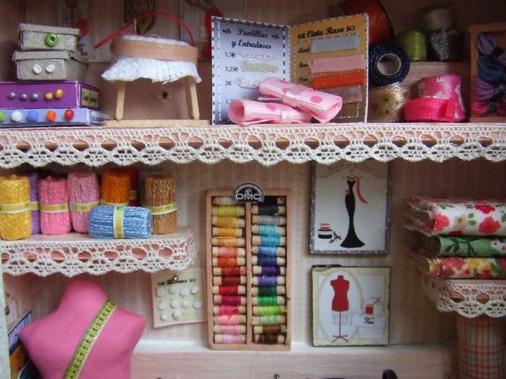 a dollhouse with lots of craft supplies on the shelves and in it's display case