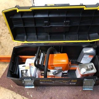 an open tool box filled with tools on the ground