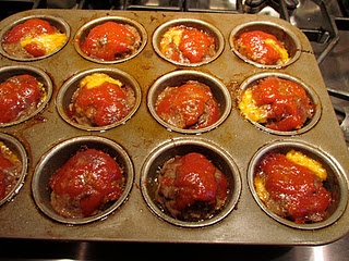 a muffin tin filled with meatballs covered in marinara sauce and cheese on top