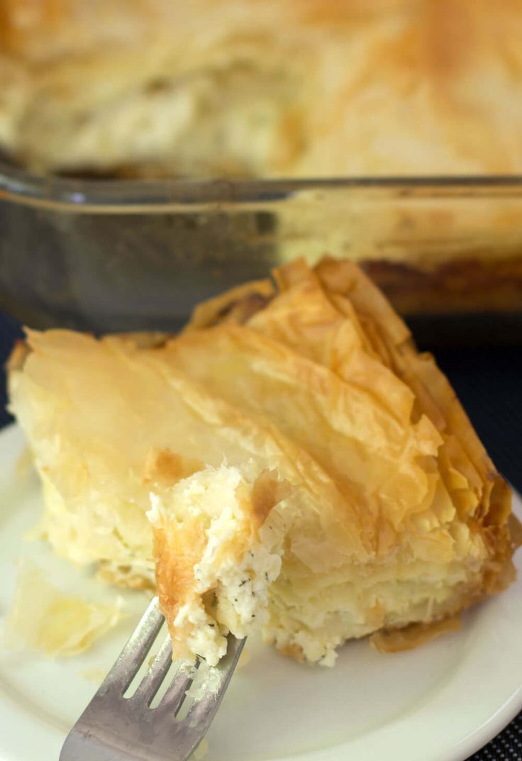 a piece of pie sitting on top of a white plate with a fork in it