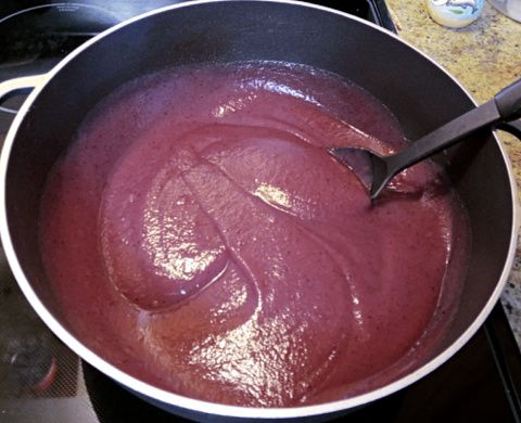 a pan filled with red liquid on top of a stove