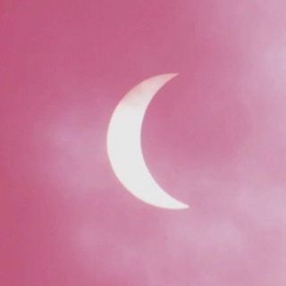 the moon is seen through the clouds on a pink sky