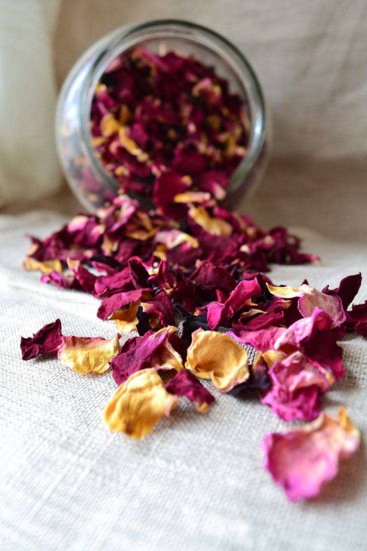 dried flowers in a glass jar on a bed