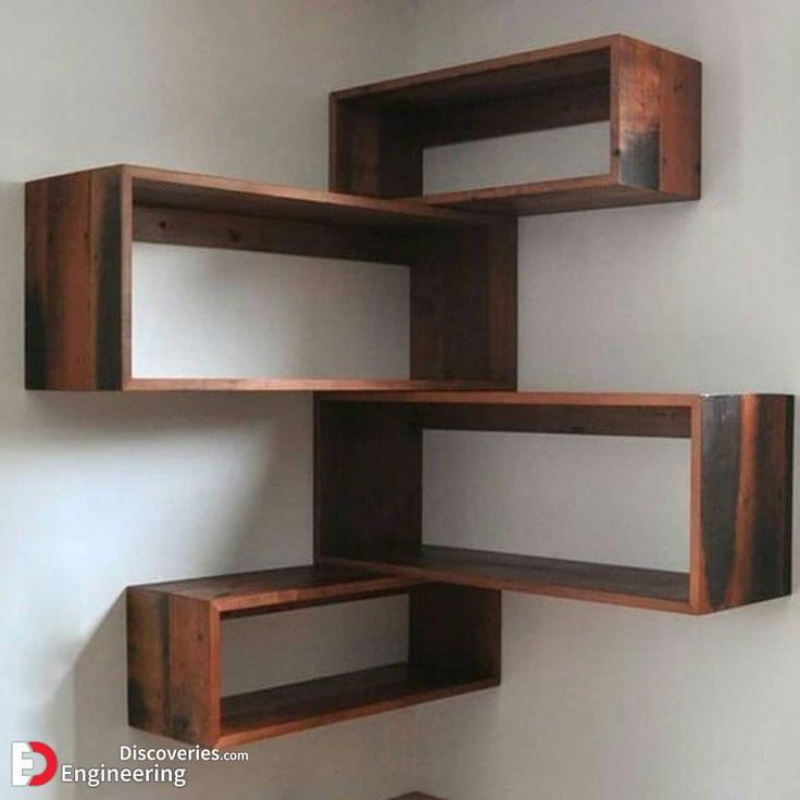 three wooden shelves on the wall with one shelf open to show books and other items