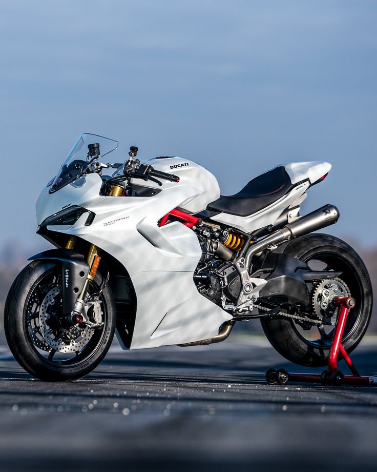 a white motorcycle parked on top of a parking lot