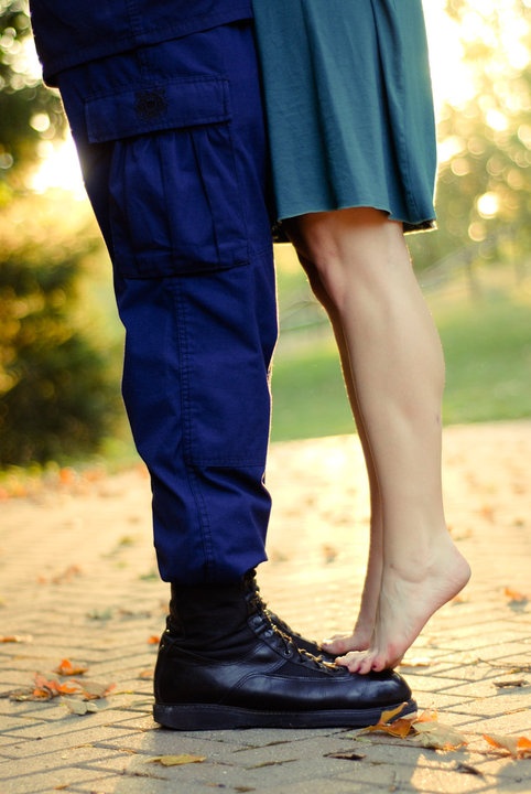 a man and woman standing next to each other with their feet on the ground in front of them