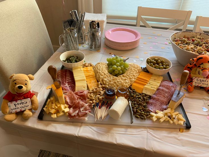 a table topped with lots of different types of cheese and meats on top of it