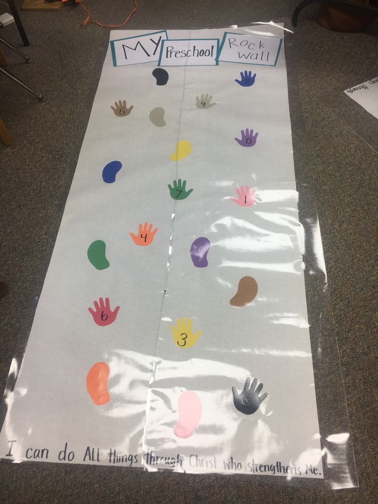 a paper bag with handprints on it sitting on top of a carpeted floor