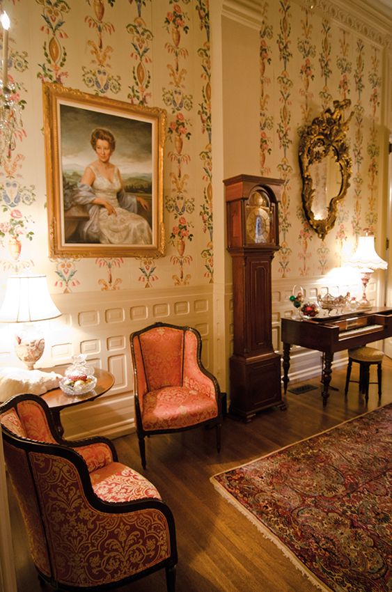 a living room filled with furniture and a painting on the wall next to a grandfather clock