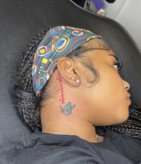 a woman with a small tattoo on her neck and behind her head is sitting in a chair