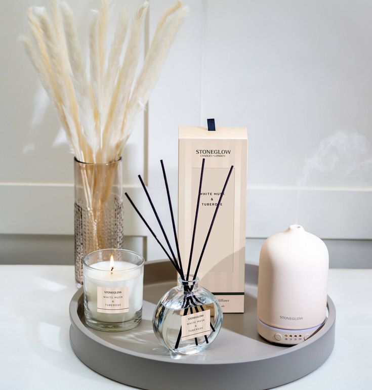 an assortment of reeds and candles on a tray