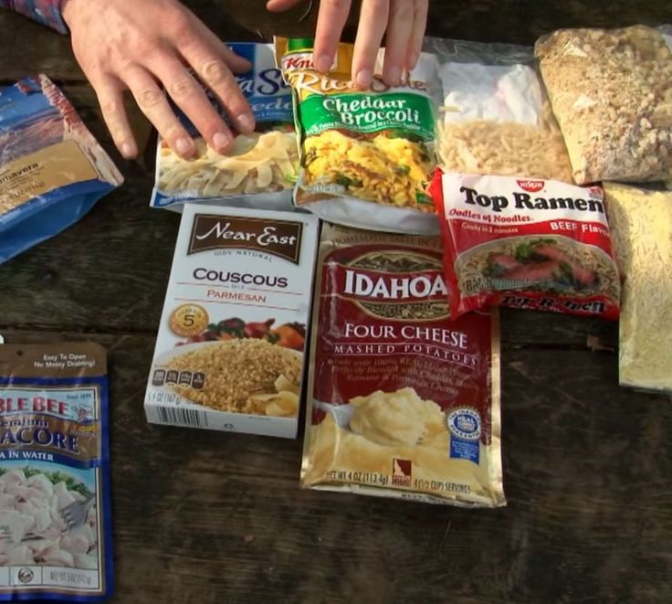 some food that is laying out on a picnic table with it's wrappers