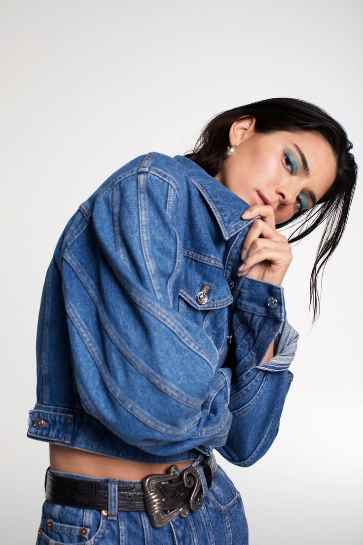 a woman wearing a jean jacket posing for the camera