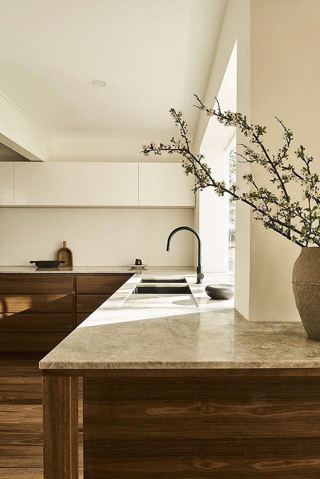 a vase filled with flowers sitting on top of a counter next to a kitchen sink