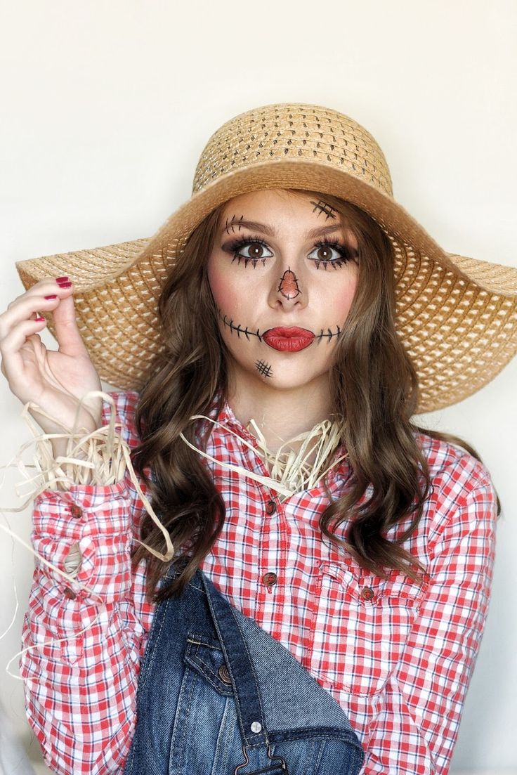 a woman in a straw hat with makeup on her face