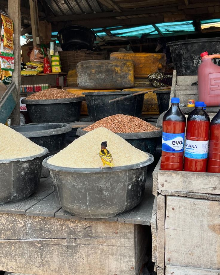 several buckets filled with food sitting on top of a wooden table next to other containers