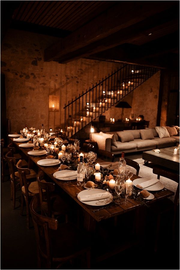 a long table is set with candles and plates