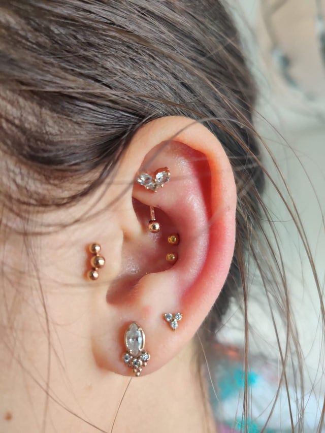 a close up of a person's ear with three different piercings on it