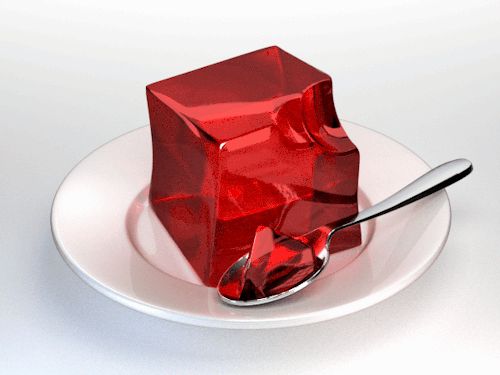 a red cube on a white plate with a spoon