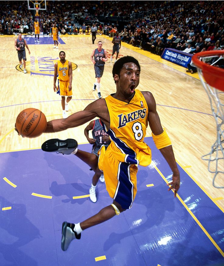 a basketball player is in mid air after going to dunk the ball during a game