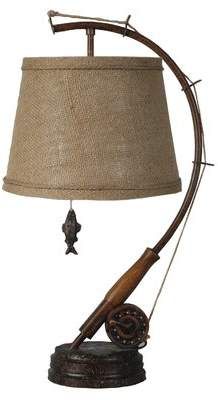 a lamp that is sitting on top of a wooden stand with a fishing pole attached to it