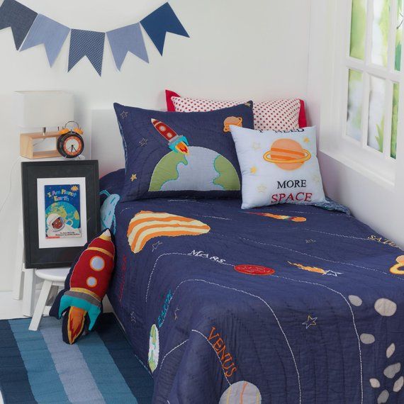 a child's bedroom with space themed bedding and decor