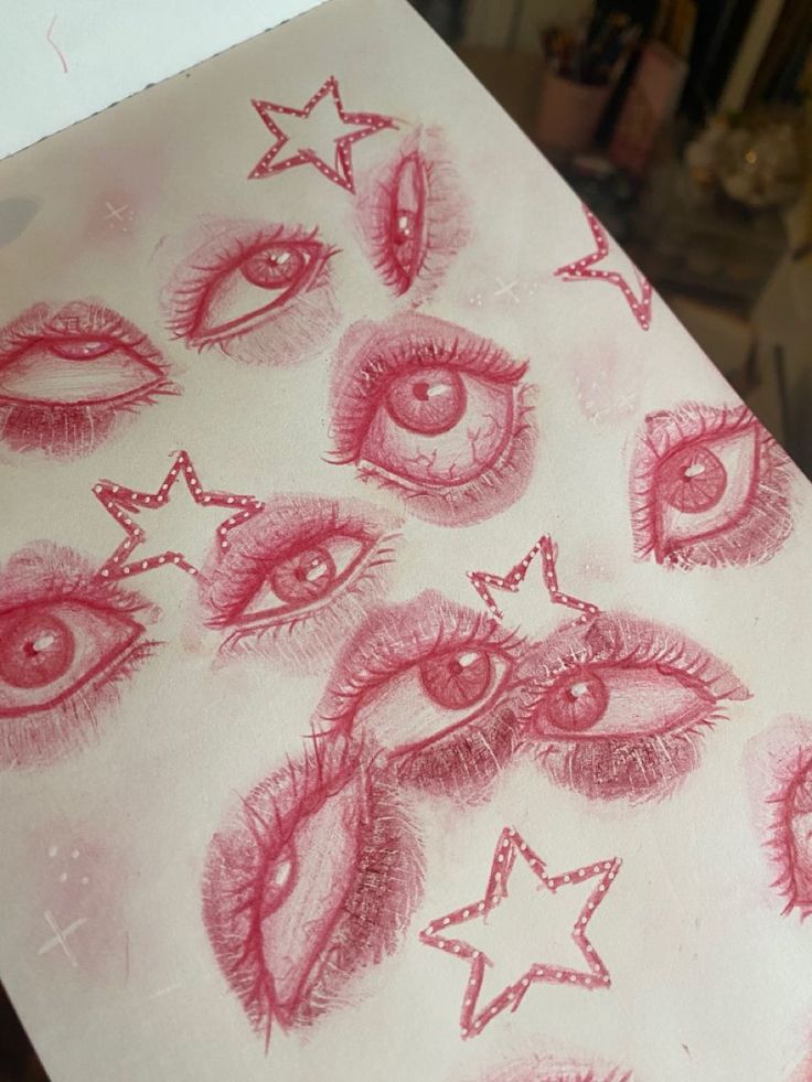 the drawing shows many different types of eyes and stars on white paper with red ink