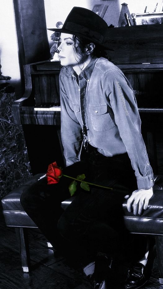 a man sitting on top of a stool next to a piano