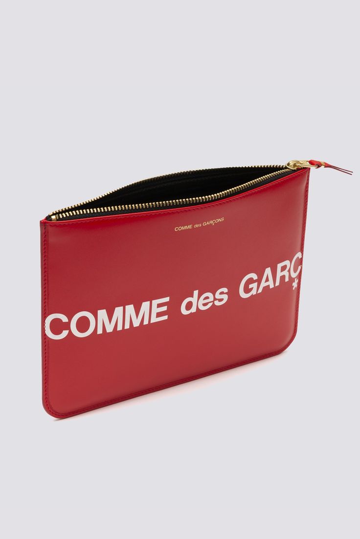 Single large pocket pouch in red with huge Comme Des Garçons logo. Long rectangular silhouette with leather lining. Tonal zipper with V-tipped zip pull. Ideal for coins, cards and cash. - 100% Cowhide - 215mm x 160mm - Made in Spain Classic Red Bag With Card Slots, Modern Red Bags With Card Slots, Luxury Red Wallet With Removable Pouch, Red Leather Clutch Pouch, Classic Red Wallets With Removable Pouch, Classic Red Pouch Clutch, Red Leather Wallet With Removable Pouch, Red Leather Clutch Wallet, Pop Up Shops