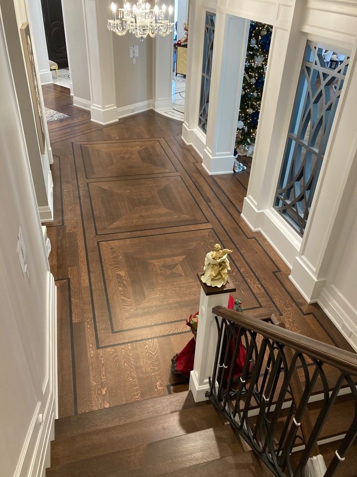 a hallway with wood floors and chandelier in the center is decorated for christmas