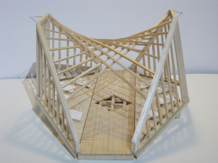 a model of a wooden structure on top of a white table with no people around it