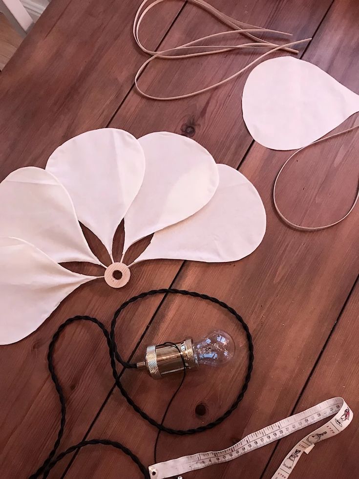 paper flowers are laid out on the floor with measuring tape and other crafting supplies