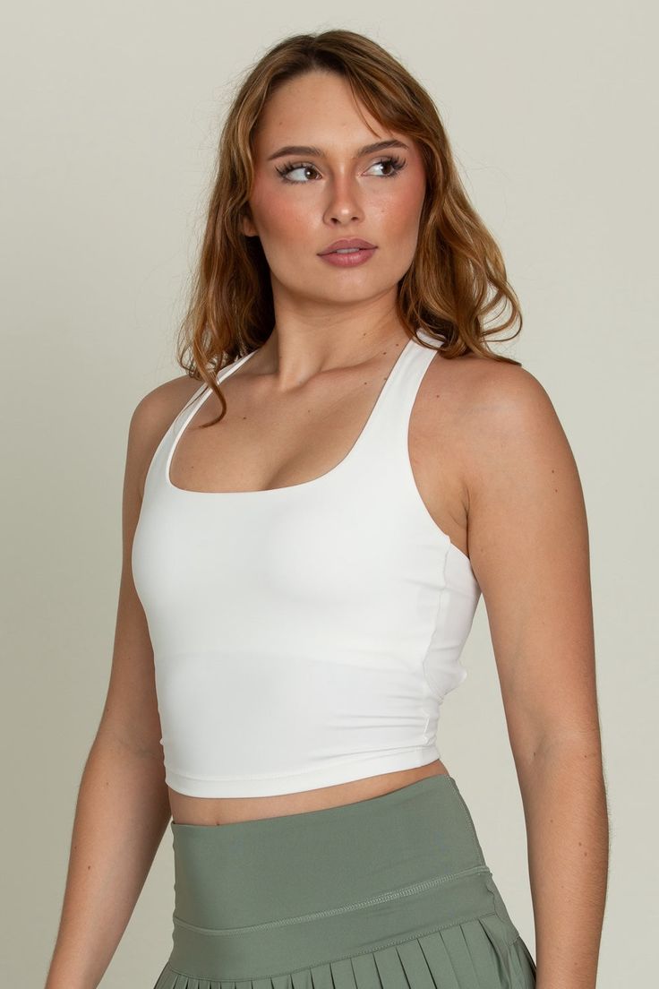 Our Whiteout Criss Cross Back Yoga Tank is our newest athletic tank and it is so flattering! It has a U-shaped front that offers coverage and a cute criss-cross style back. It features our ultra smooth, sweat-wicking material that you can wear when active or just out for the day! It is complete with built-in padding that can be removed if needed. Sporty Seamless T-back Tank Top, Stretch Crop Top With Strappy Back For Sports, Sleeveless Yoga Tank Top With Built-in Padding, Solid T-back Tank Top For Sports, Versatile Moisture-wicking Racerback Top, Yoga Tank Top With Built-in Padding, Versatile Gym Tops With Built-in Padding, Athleisure Activewear With Seamless Construction And Strappy Back, Compressive Athleisure Tank Top For Light Sports