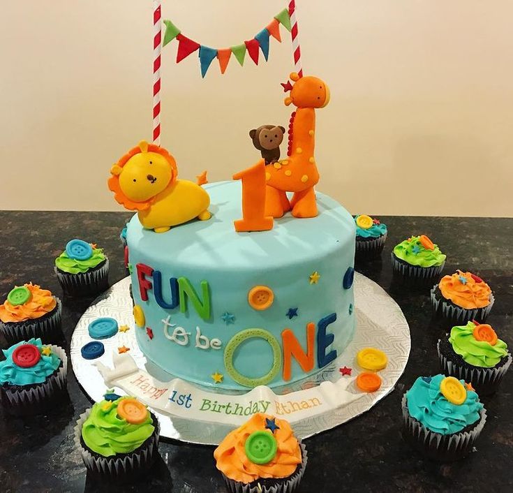 a birthday cake with cupcakes on the table