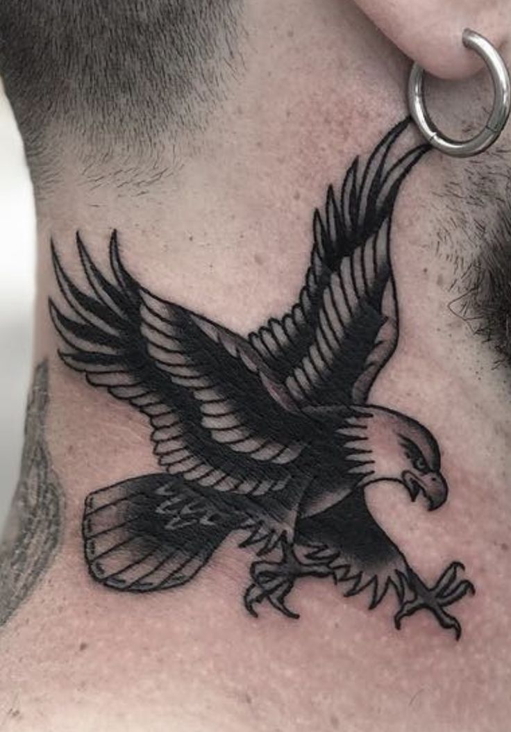 an eagle tattoo on the back of a man's neck