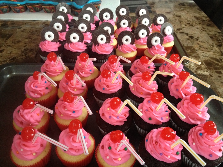 cupcakes with pink frosting and monkey faces on them are arranged in rows